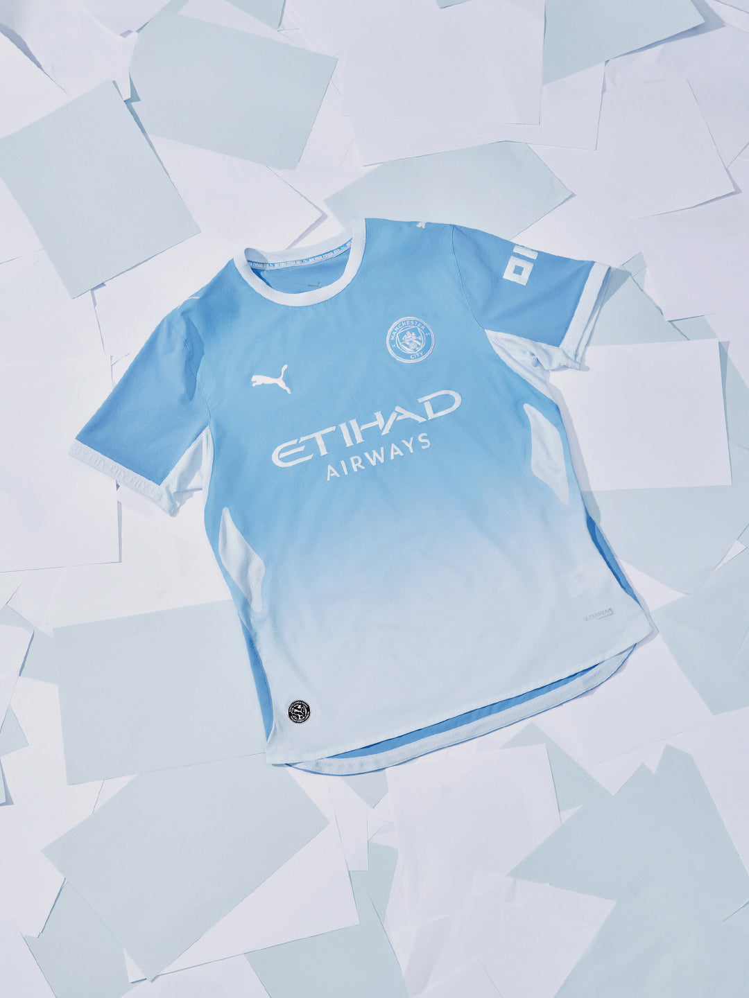 Light blue sports jersey with Puma logo on a light gray background