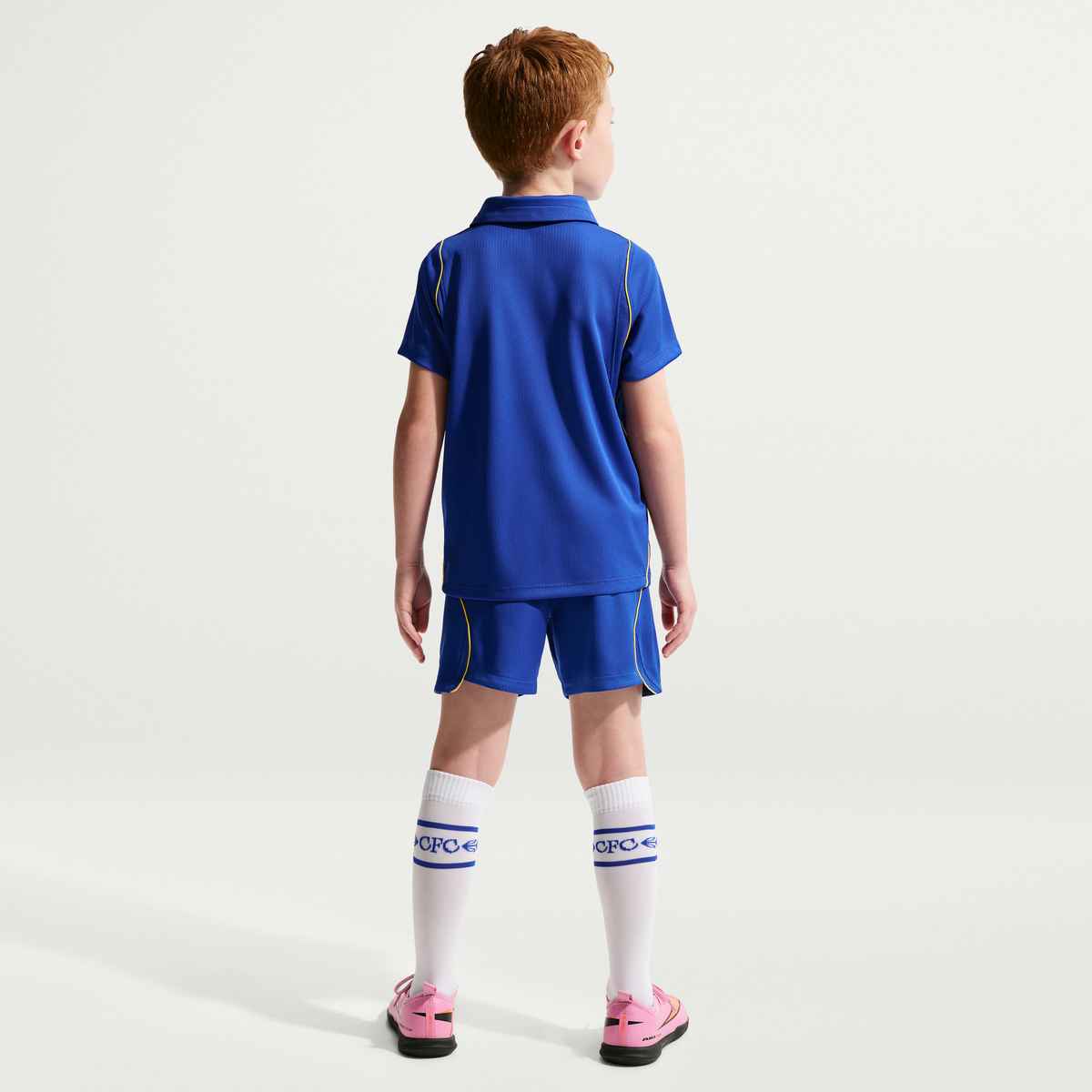 Child wearing a blue sports outfit with white socks on a light gray background