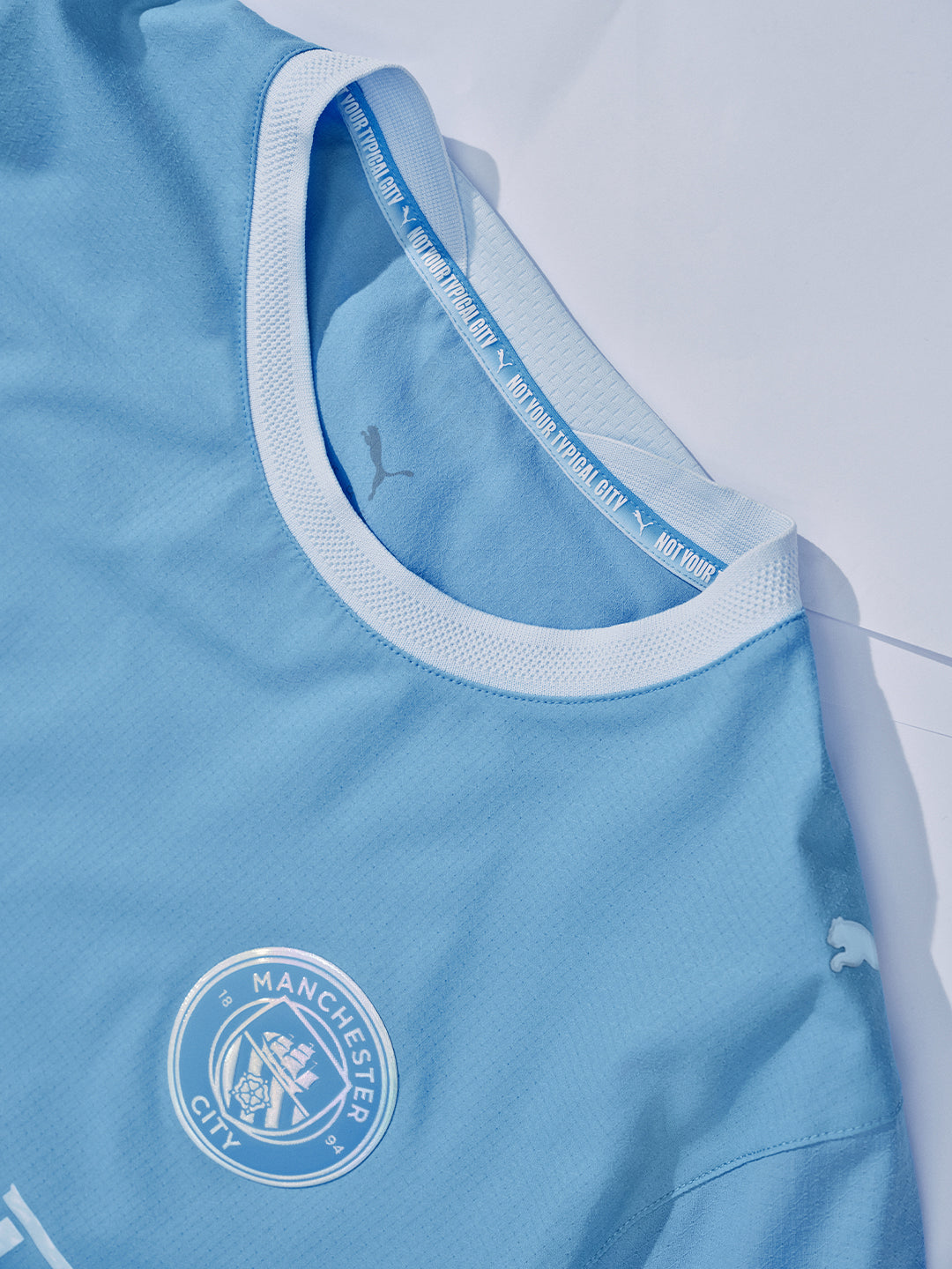 Light blue sports jersey with Manchester City logo and Puma branding.