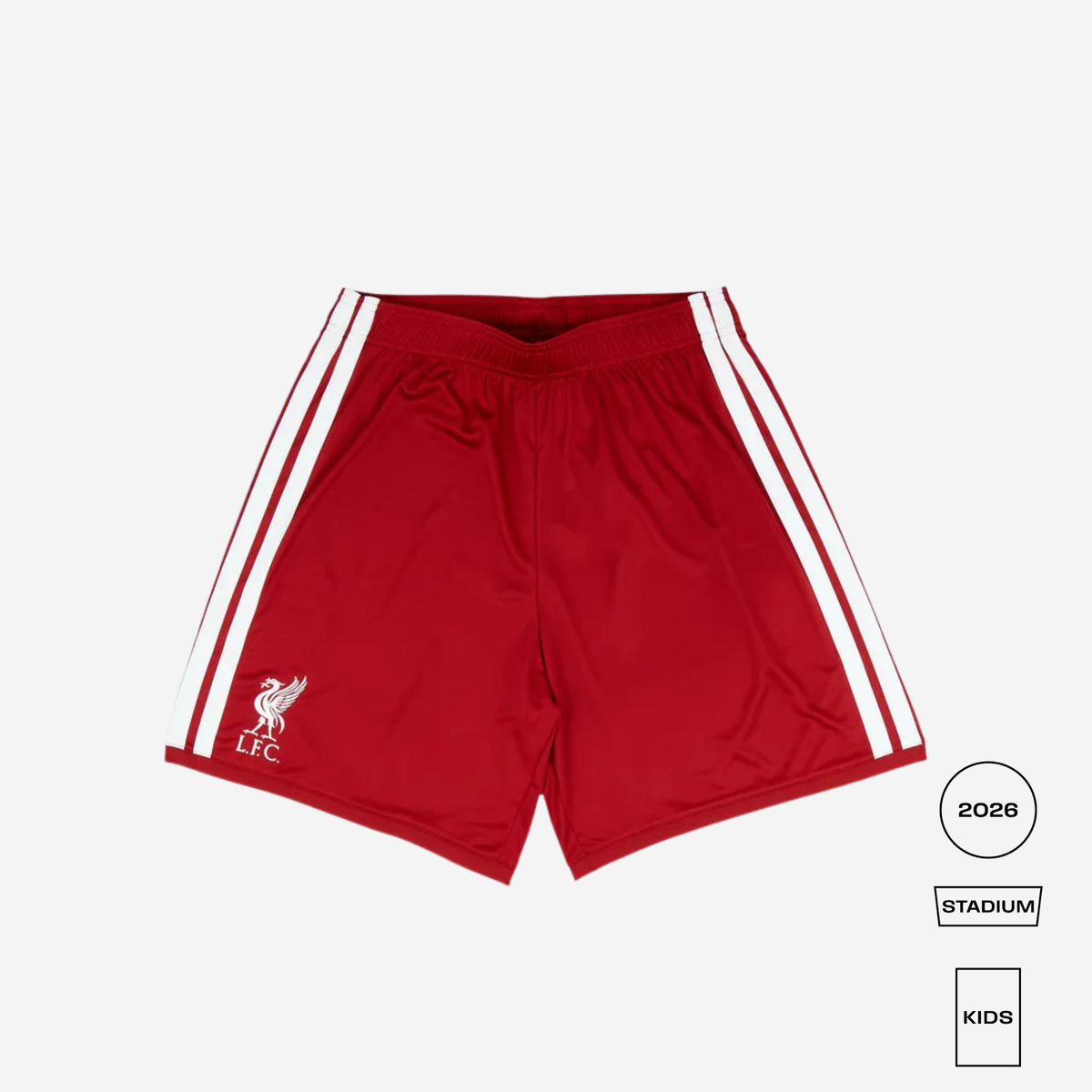 Red Liverpool football shorts with white side stripes and a white club crest on the left leg, shown flat on a light gray background with size/style labels at the bottom right.