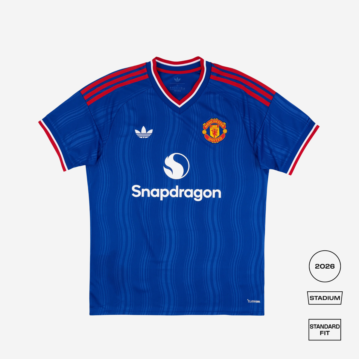 A blue Manchester United football jersey by Adidas, featuring red shoulder stripes, a white Snapdragon sponsor logo, and the club crest on the chest, displayed on a light gray background with fit labels.