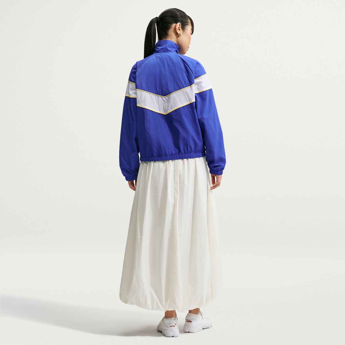 Person wearing a blue and white jacket with a white background