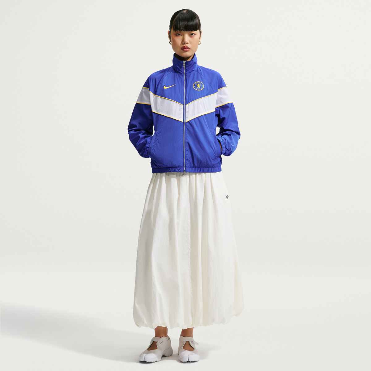Person wearing a blue and white jacket with a Nike logo on a white background