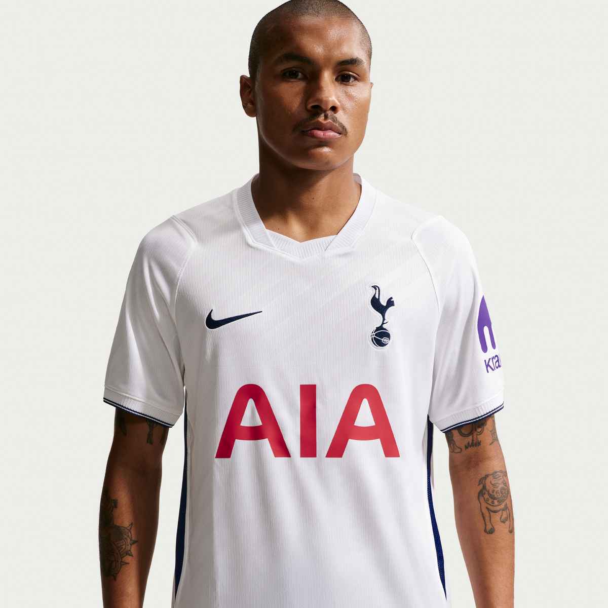 Person wearing a Tottenham Hotspur football jersey with Nike logo on a white background