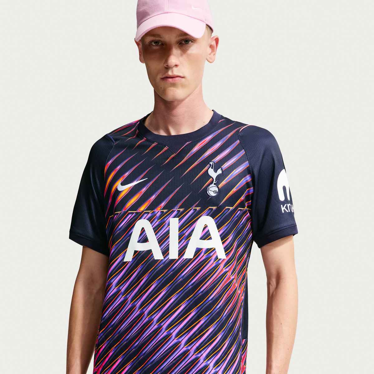 Person wearing a Tottenham Hotspur sports jersey with colorful patterns and 'AIA' branding.